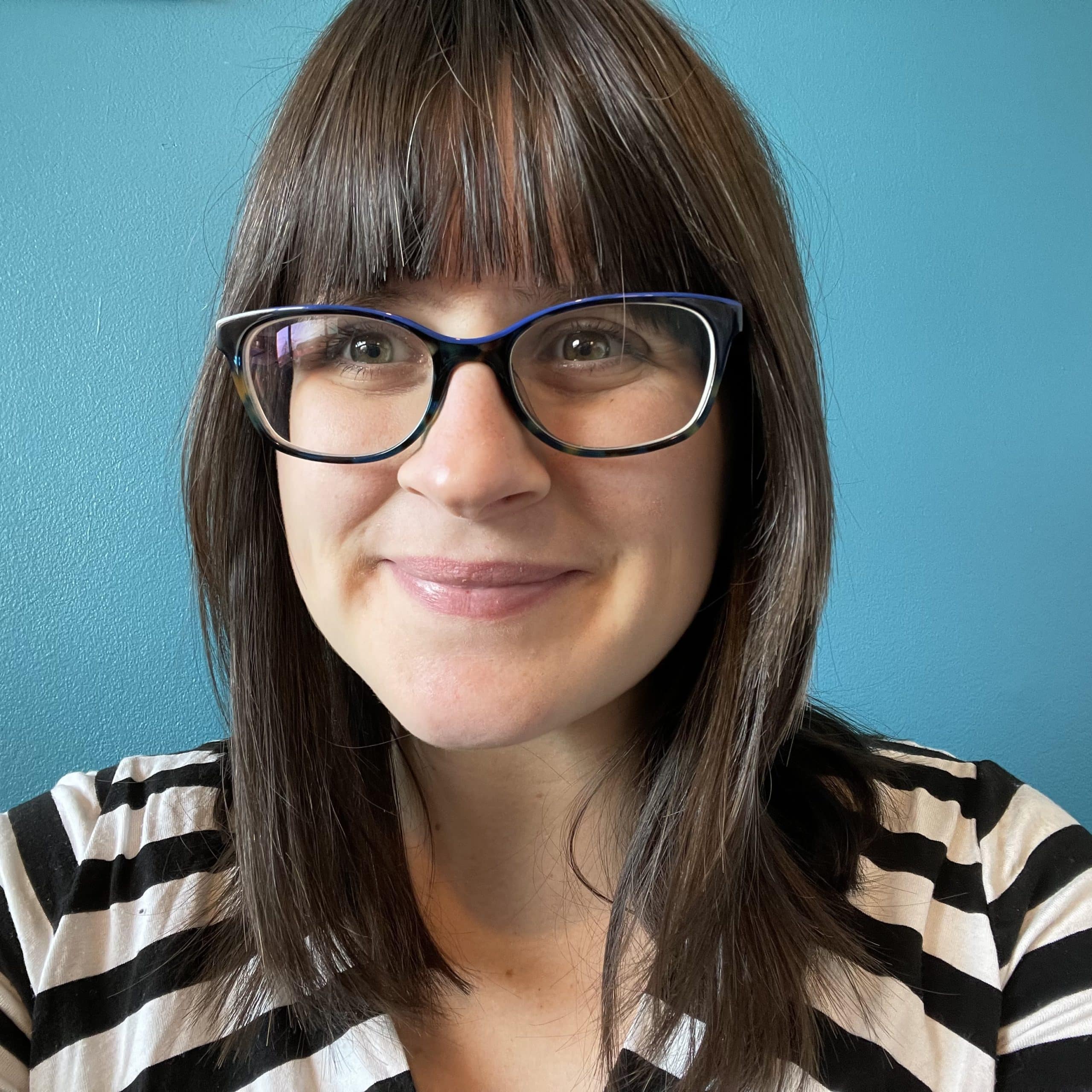 Abbie Horning - Communications Manager at Stornaway.io A headshot of a women looking towards the camera. She had dark hair and wears glasses. The background is a turquoise coloured wall.