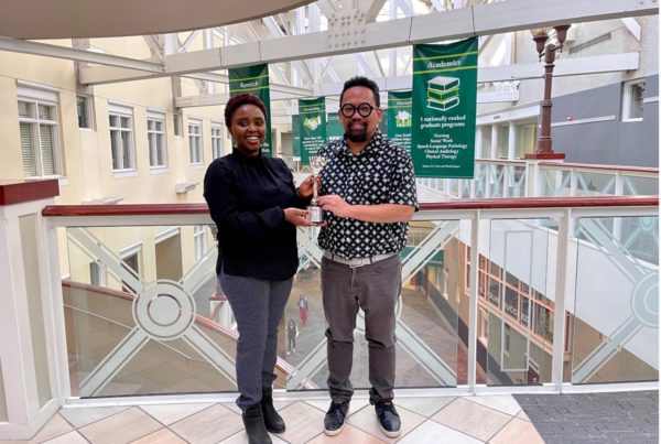 Kingori and Durado with the Davey Awards Plaque. DatingForward has so far won 2 award. 2 people stand in a university building holding an award.