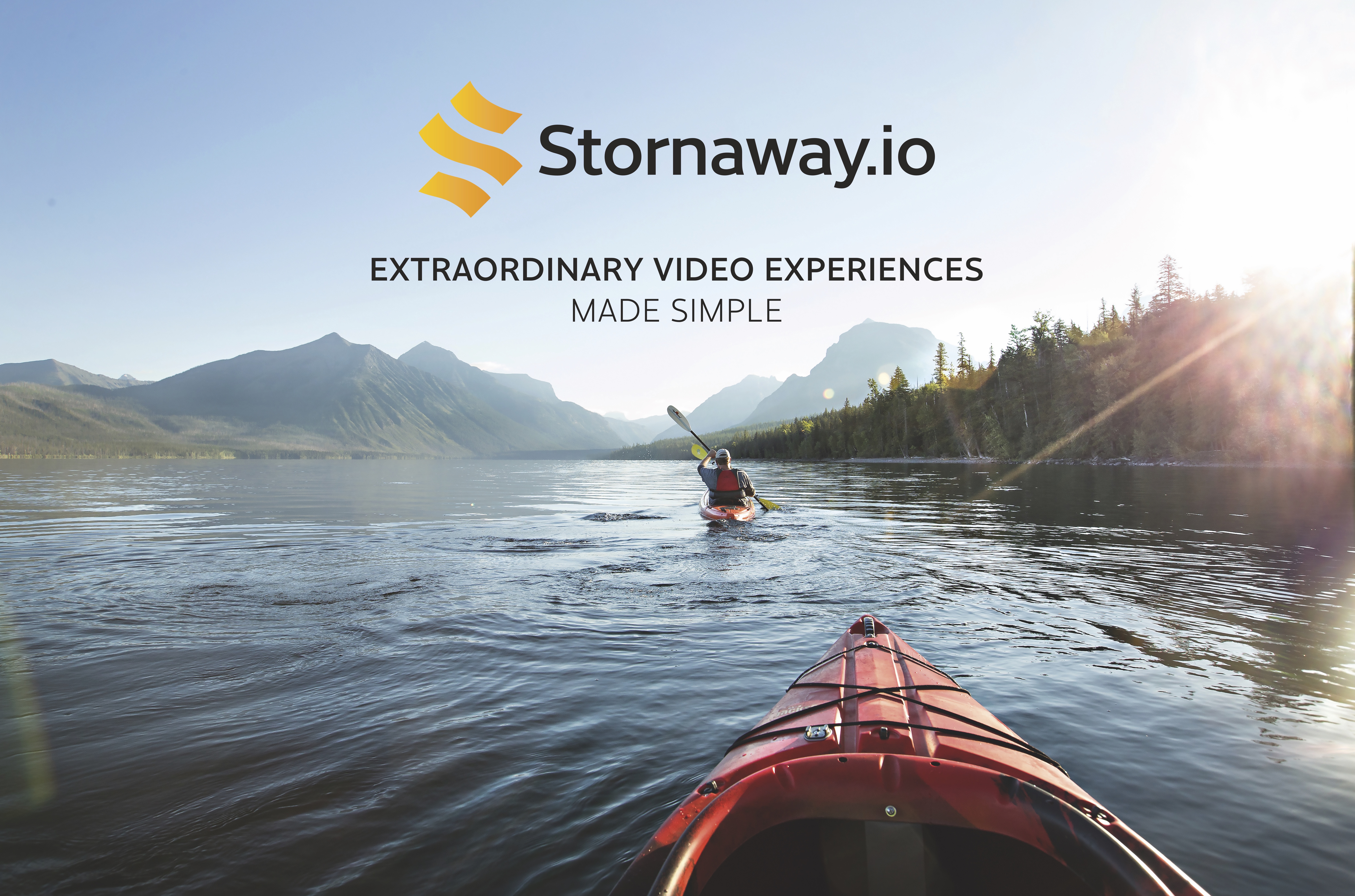 Point of view shot: The front of a red kayak follows another kayaker in the distance on a clam water towards far off mountains.