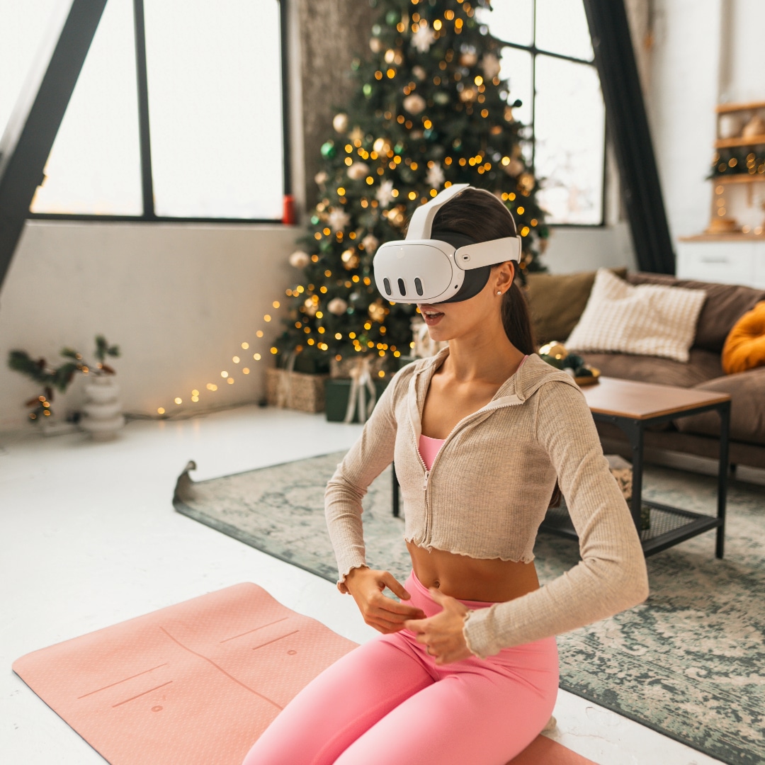 360 meta quest headset for VR - a woman in exercise clothes kneels in on a yoga mat. She is wearing. VR headset.
