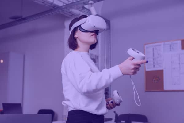 Woman in meta quest VR headset - a women stands in an office in a VR headset. She holds controllers in her hands.