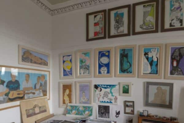 Inside Alasdair Gray's studio - walls covered in framed paintings.
