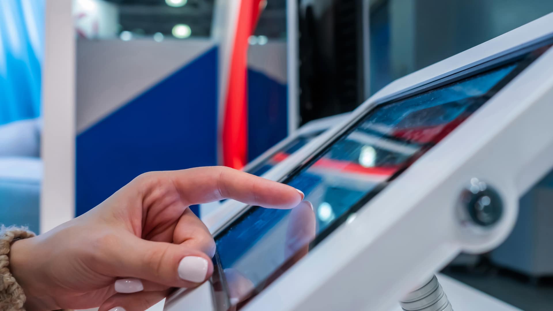 A trade show attendee interacts with a tablet at a conference. They're playing an adaptive media project created specifically for the event.