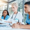 Healthcare training. A senior medical professional runs through a training module with two junior medical professionals