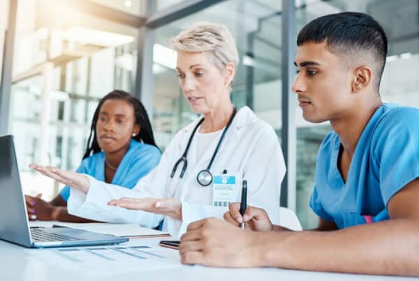 Healthcare training. A senior medical professional runs through a training module with two junior medical professionals