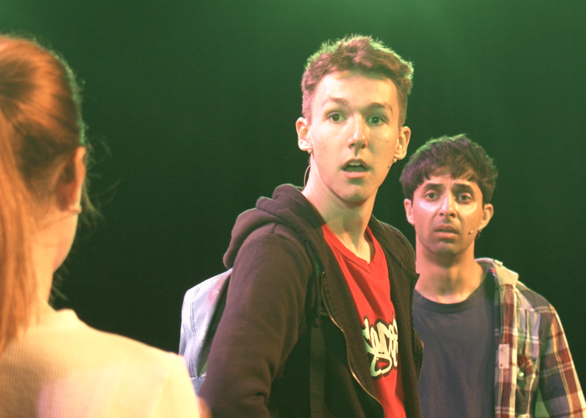 A moment from a theatre show for Year 6 students. Two boys look surprised at something off screen.